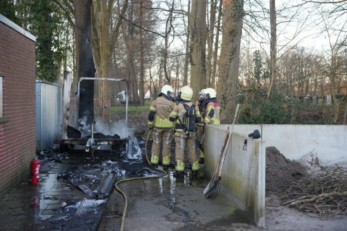 Brandweer staat bij de uitgebrande aanhanger. © PNN